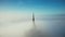 Beautiful aerial panning shot of glorious golden spire at Mont Saint Michel castle covered by epic sunrise fog clouds.