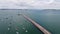 Beautiful aerial shot of a light house at the end of a pier.