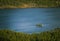 A beautiful aerial view of an autumn forest with lake in Norway. Pine trees from above.