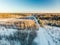 Beautiful aerial view of snow covered fields with a road among trees. Rime ice and hoar frost covering trees