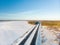 Beautiful aerial view of snow covered fields with a two-lane road among trees. Rime ice and hoar frost covering trees