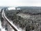 Beautiful aerial view of snow covered pine forests and a road winding among trees. Rime ice and hoar frost covering trees. Scenic