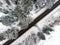 Beautiful aerial view of snow covered pine forests and a road winding among trees. Rime ice and hoar frost covering trees. Scenic