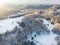 Beautiful aerial view of snow covered pine forests and a road winding among trees. Rime ice and hoar frost covering trees. Winter