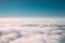 Beautiful Aerial View Of Sunny Clear Sky Over White Fluffy Clouds From Height Flight Of Plane. Bright White And Blue