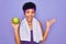 Beautiful african american afro sporty woman doing exercise wearing towel eating green apple very happy and excited, winner