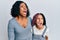 Beautiful african american mother and daughter wearing casual clothes and hugging angry and mad screaming frustrated and furious,