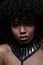 Beautiful african american nacked woman with curly hairstyle wearing leather necklace with metal inserts
