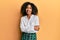 Beautiful african american woman with afro hair wearing scholar skirt happy face smiling with crossed arms looking at the camera
