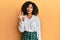 Beautiful african american woman with afro hair wearing scholar skirt showing and pointing up with fingers number four while