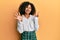 Beautiful african american woman with afro hair wearing scholar skirt showing and pointing up with fingers number seven while