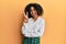 Beautiful african american woman with afro hair wearing scholar skirt smiling with happy face winking at the camera doing victory