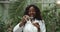 Beautiful African American woman microbiologist scientist biologist researcher with test tube liquid, plant seedling lab