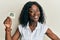 Beautiful african young woman holding paper with aquarius zodiac sign looking positive and happy standing and smiling with a
