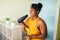 Beautiful afro woman drying hairs and singing like a microphone