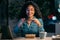 Beautiful afro young business woman taking a photo with her smartphone while eating pasta sitting in the office