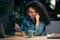 Beautiful afro young business woman working with computer while eating pasta sitting in the office