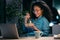 Beautiful afro young business woman working with computer while eating pasta sitting in the office