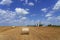 Beautiful Agricultural Landscape Scenery With Hay Bales and Grain Silos