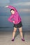 Beautiful aisan girl doing exercises on the beach. against the backdrop of the sea