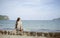 Beautiful alone young asian woman at seashore near the beach.blurred sea and sky in background.selective focus.filtered image