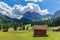 Beautiful alpine landscape with freshly cut meadows on a background of Italian Dolomites mountains.