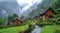 Beautiful Alps landscape with village, green fields, mountain and waterfall. Travel, landscape