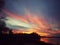 Beautiful and amazing red and gold sunset over a still lake with park silhouette