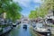 Beautiful Amsterdam Canals with boats docked alongside houses Netherlands