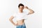 Beautiful androgynous man in crop top showing peace sign and smiling, standing over white background