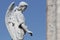 Beautiful angelic statue stands against a bright blue sky in a peaceful cemetery setting