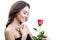 Beautiful angry girl receives one red rose. She is surprised, looking at the flowers and smiling.