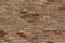 Beautiful antique brick wall texture sprinkled with hot pepper hued bricks of red, tan, pink and brown, with arched window