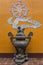 Beautiful antique bronze incense burner against orange wall