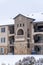 Beautiful apartment with front gable roof and arched balcony viewed in winter