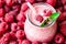 Beautiful appetizer pink raspberries fruit smoothie or milk shake in glass jar with berries background, top view.