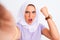 Beautiful arabian girl wearing hijab make selfie by camera over isolated white background annoyed and frustrated shouting with