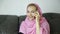 Beautiful arabian woman in pink hijab sitting on a sofa in a cafe and talking on cell phone