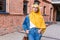 Beautiful Arabic muslim woman wearing yellow hijab, stylish female portrait over city street.