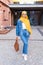 Beautiful Arabic muslim woman wearing yellow hijab, stylish female portrait over city street.