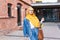 Beautiful Arabic muslim woman wearing yellow hijab, stylish female portrait over city street.