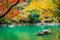 Beautiful Arashiyama river with maple leaf tree and boat around lake