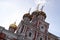 Beautiful architecture - pink church with white carved details and colorful domes and blue sky