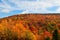 Beautiful areal view of a hill covered with vibrant autumn trees with a cloudy sky, West Virginia