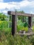 Beautiful artesian well made by stones and wheel pulley with metal bucket and rope in peaceful garden atmosphere. Retro stone