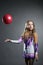 Beautiful artistic gymnast throws ball in studio