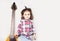 Beautiful artistic little girl playing guitar on grey background. Place for your text