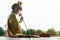 Beautiful asia women wearing traditional Thai dress and sitting on Wooden floor. Her hands is holding lotus flower and smell pink