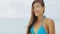 Beautiful Asian bikini woman on tropical beach vacation with windy hair
