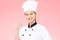 Beautiful Asian chef woman smile and make okay hand sign  on pink background